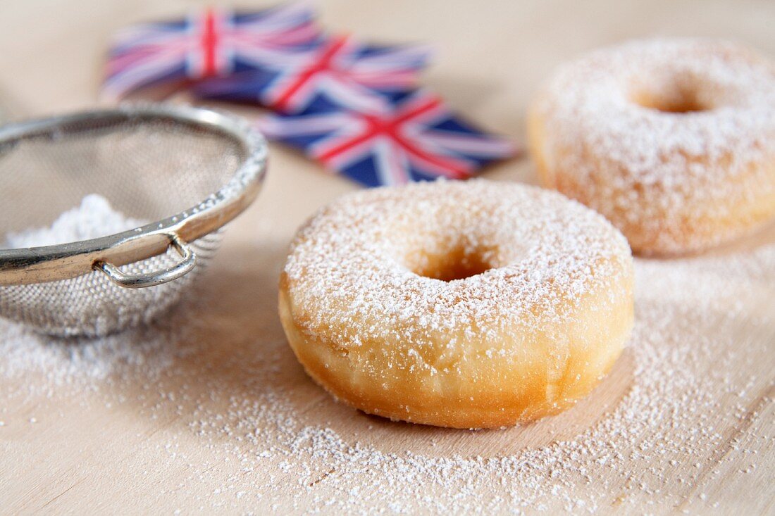 Doughnuts dusted with icing sugar with Union Jacks in the background