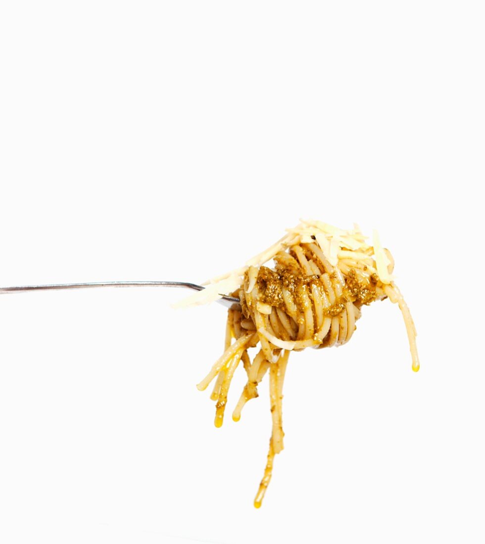A fork of spaghetti with pesto and grated cheese