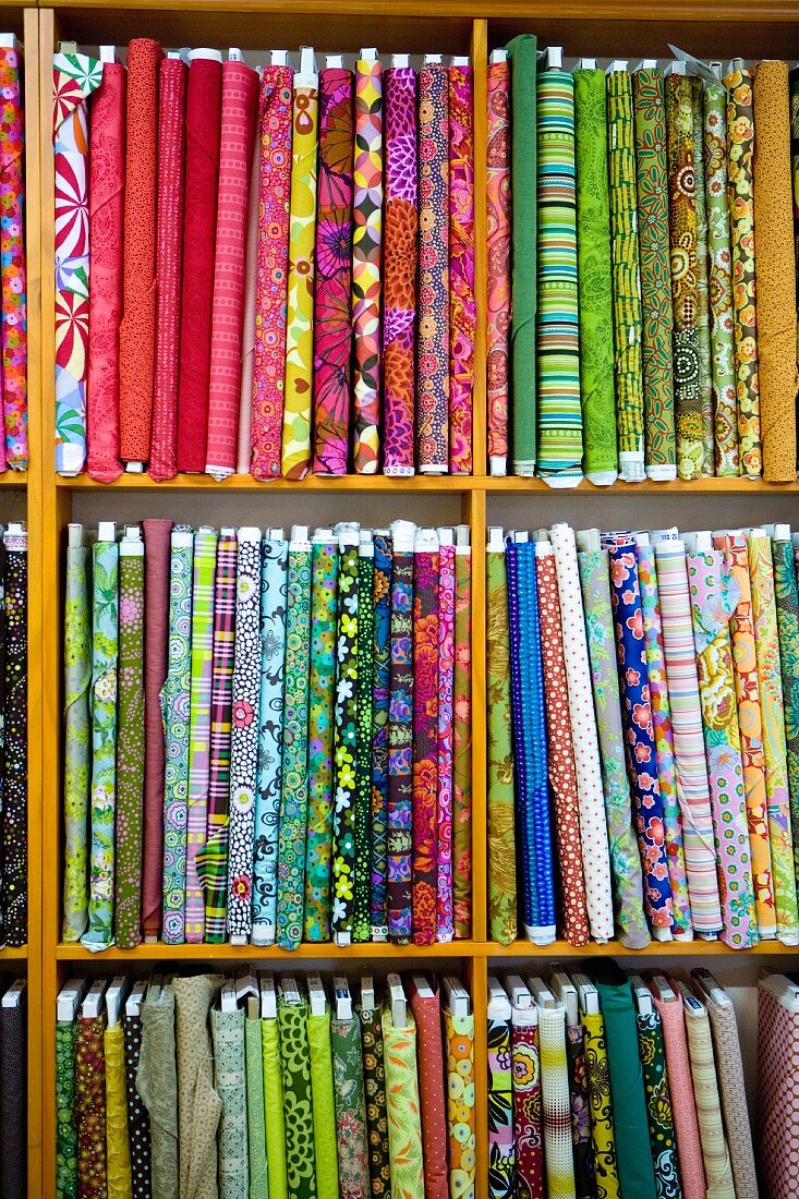 Various patterned fabrics on wooden shelves