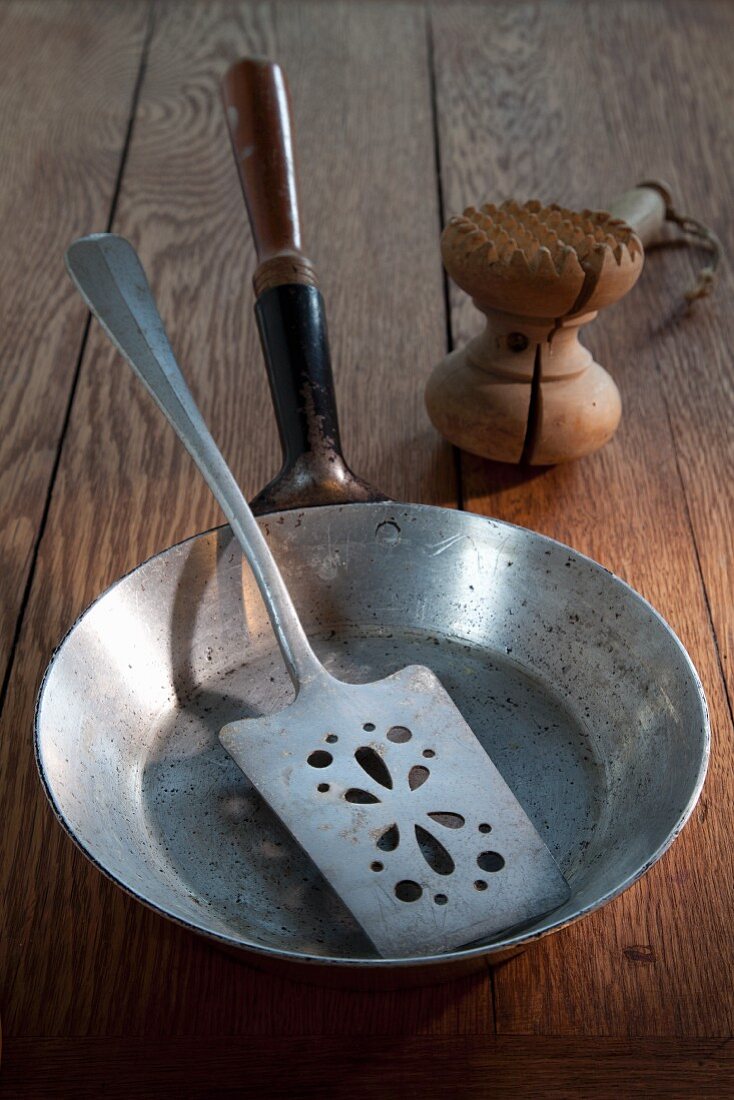 An old frying pan, a fish slice and a meat tenderiser