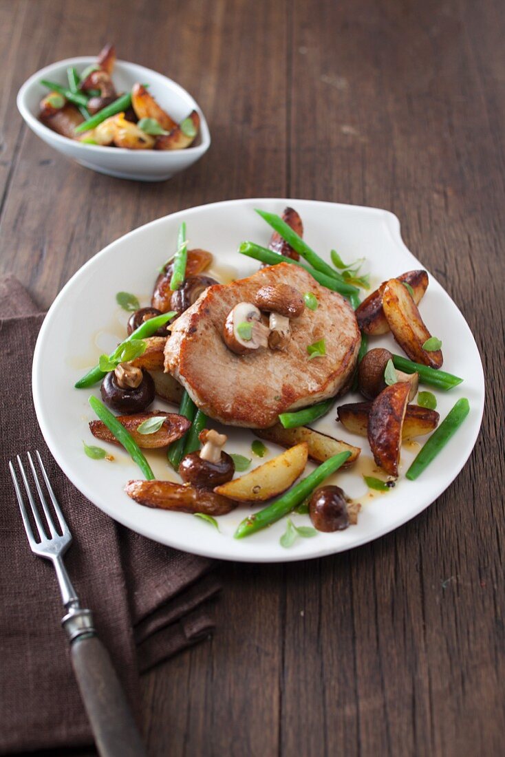 Pork loin steak with fried potatoes, mushrooms and green beans