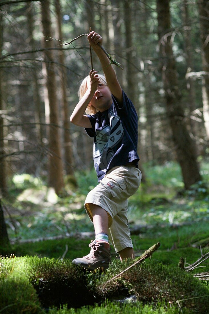 Boy playing in woods