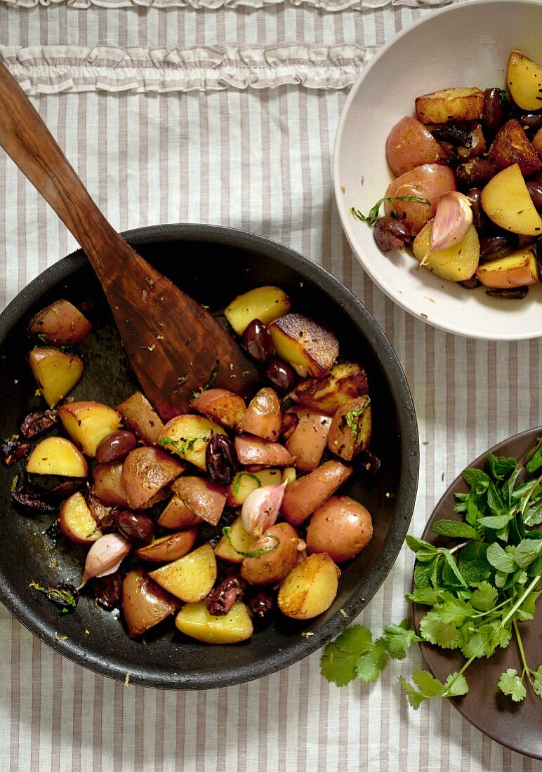 Bratkartoffeln mit Knoblauch und Oliven in der Pfanne