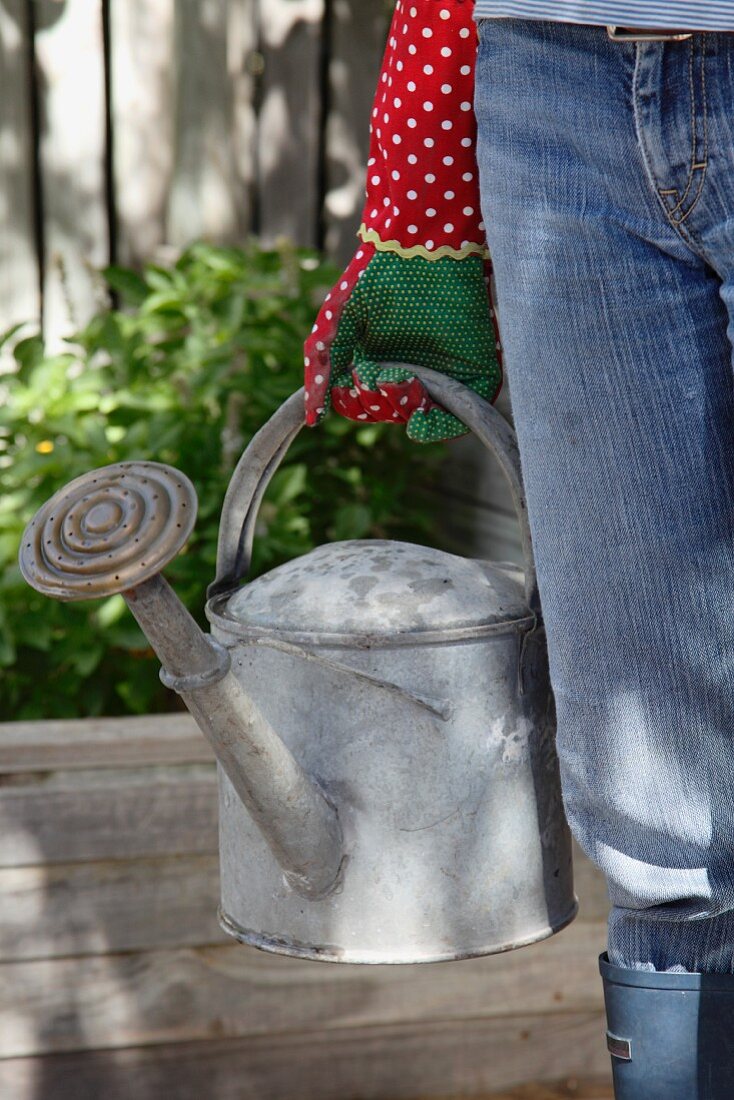 A woman carrying a watering can