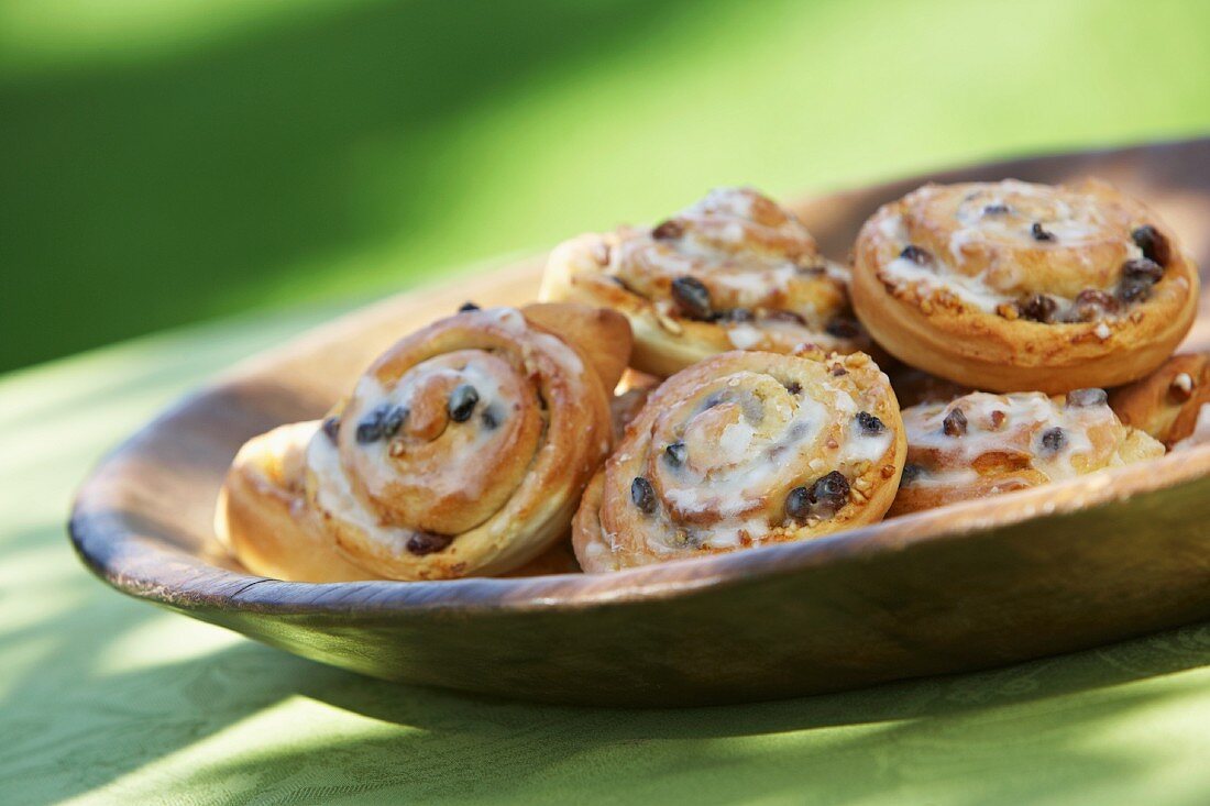 Iced Chelsea buns in a wooden bowl