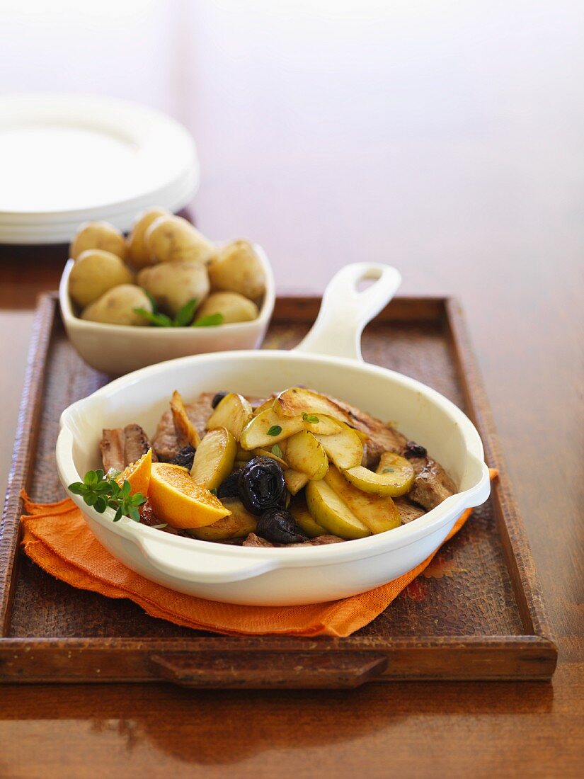 Fried pork with apples in a pan