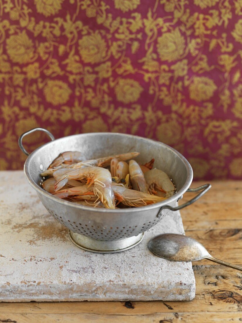 Fresh king prawns in an old colander