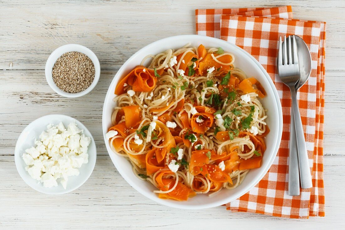 Carrot and spelt spaghetti with sheep's cheese, sesame seeds and parsley
