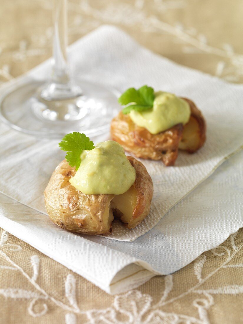 Small baked potatoes topped with avocado creme