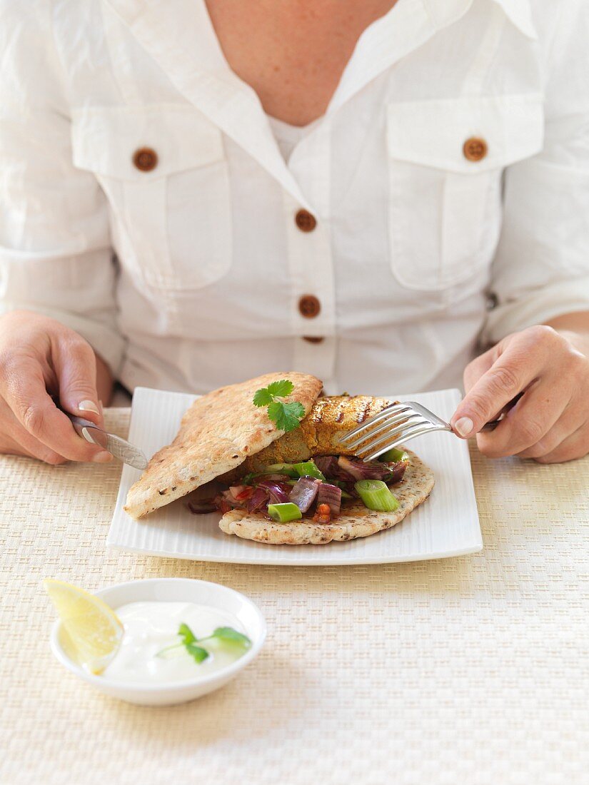 Frau isst Naan-Brot mit Schweinefleisch