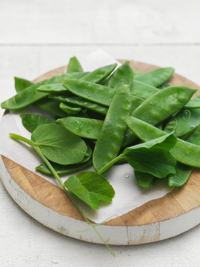 Fresh mange tout on a wooden board