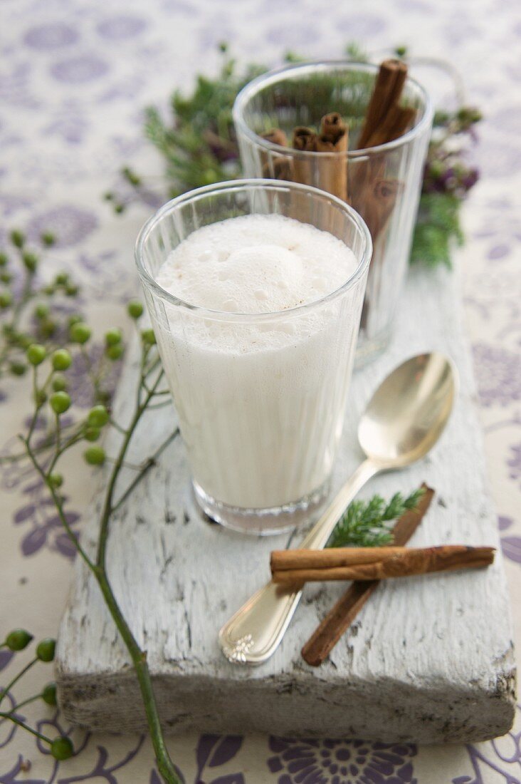 A glass of hot milk with cinnamon and honey