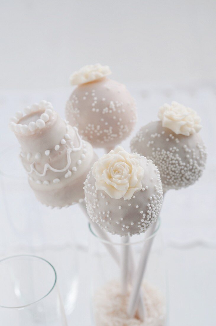 Four cake pops in a champagne glass for a wedding