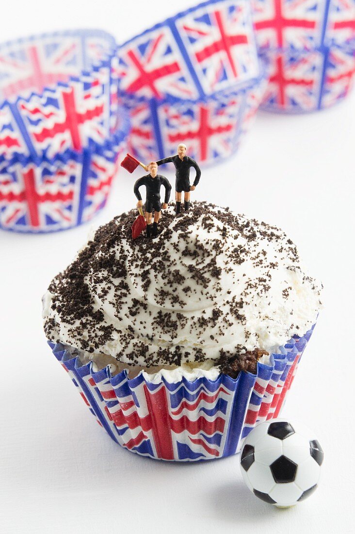 A cupcake with cream and footballer figurines (Great Britain)
