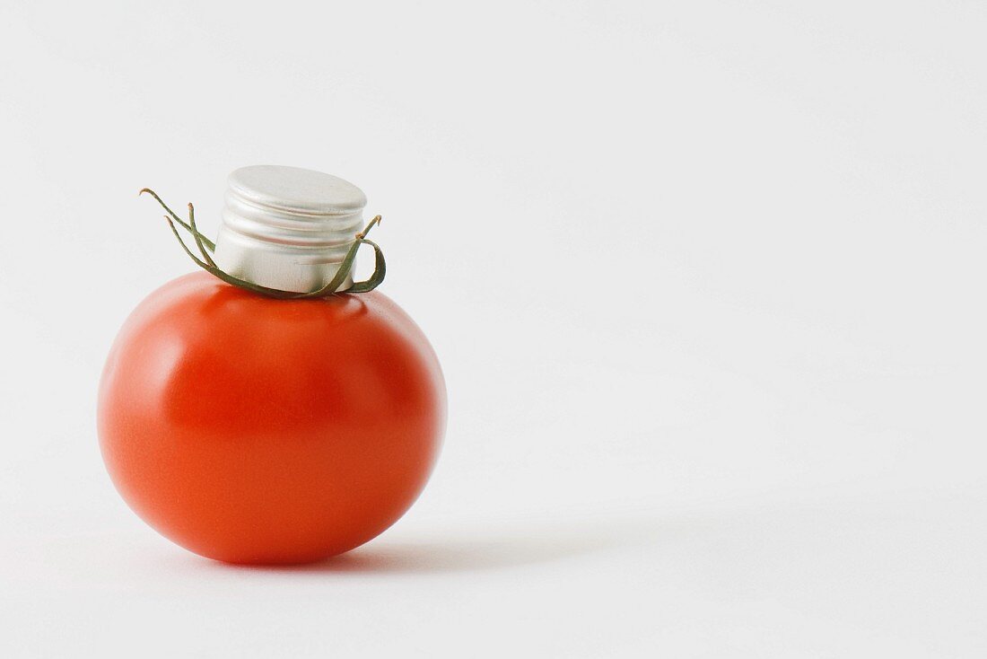 Fresh vine tomato with bottle cap on top of it
