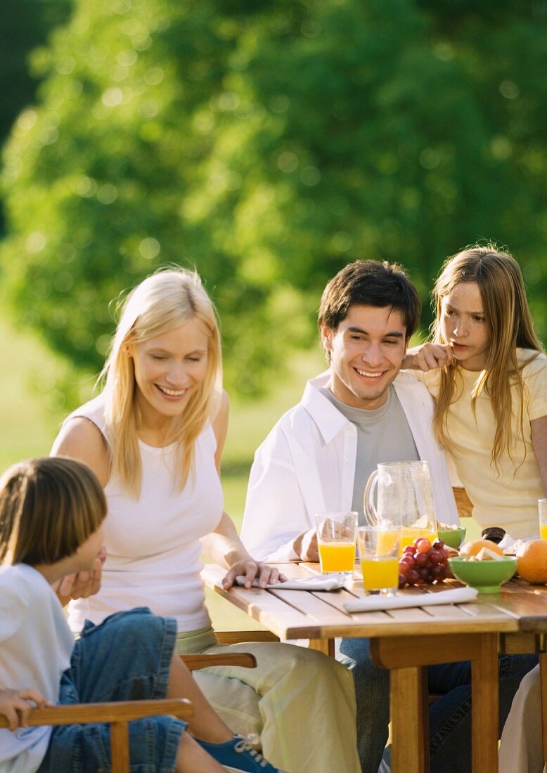 Familie isst Frühstück im Garten