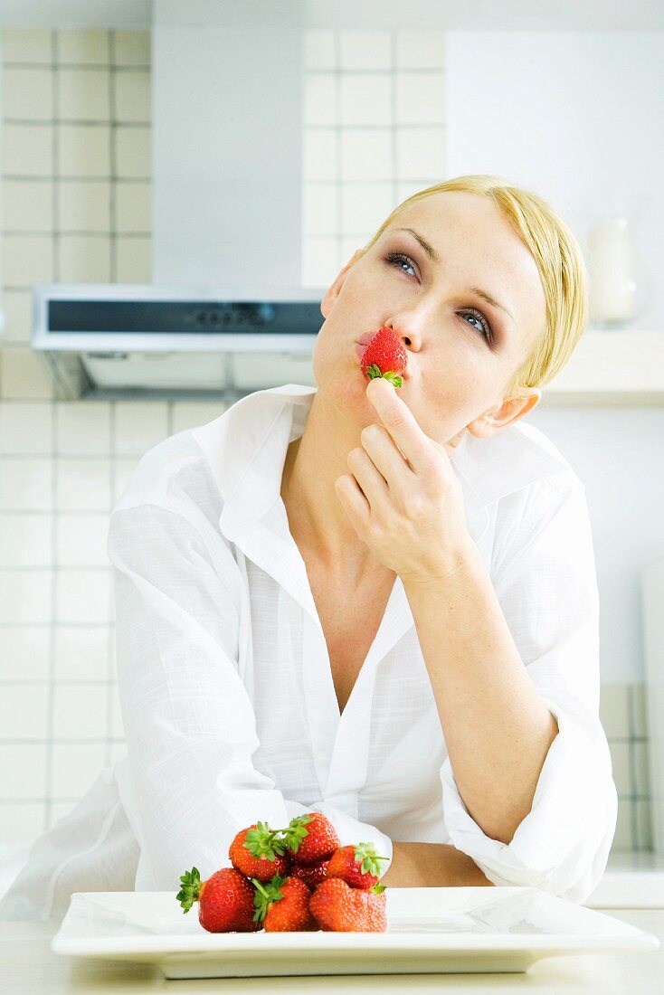 Frau hält Erdbeere