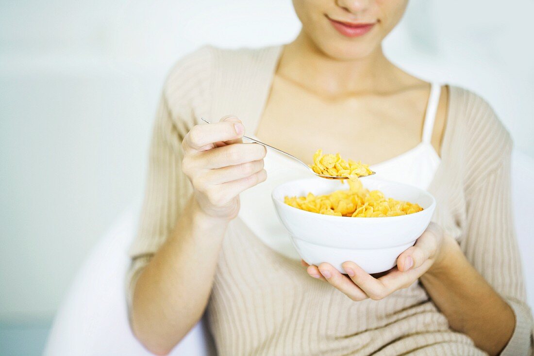 Woman holding bowl of cereal, cropped view