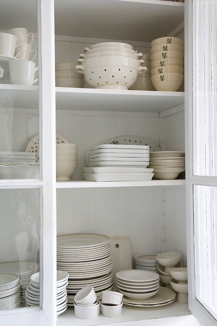 A view of vintage crockery through an open cupboard door