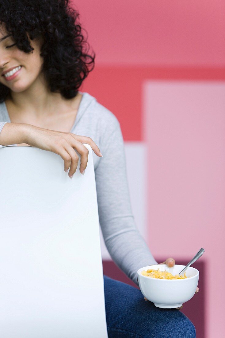 Young woman holding bowl of cornflakes