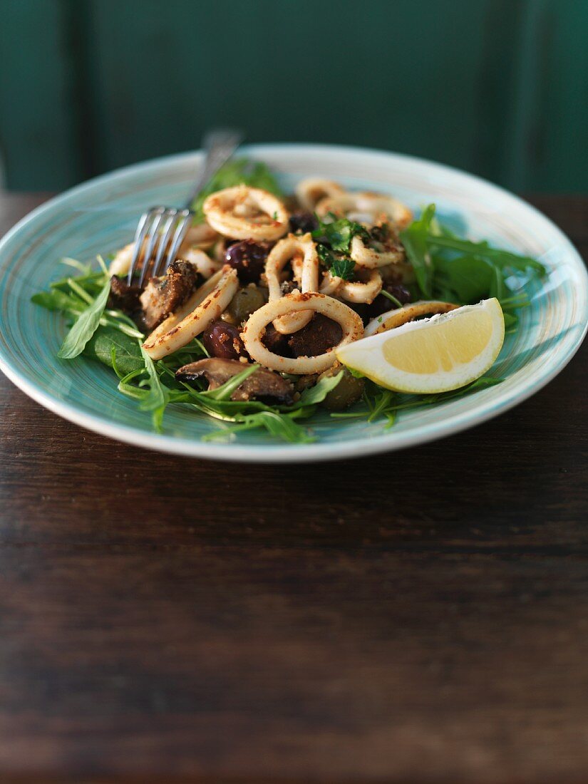 Squid rings with mushrooms, rocket and olives