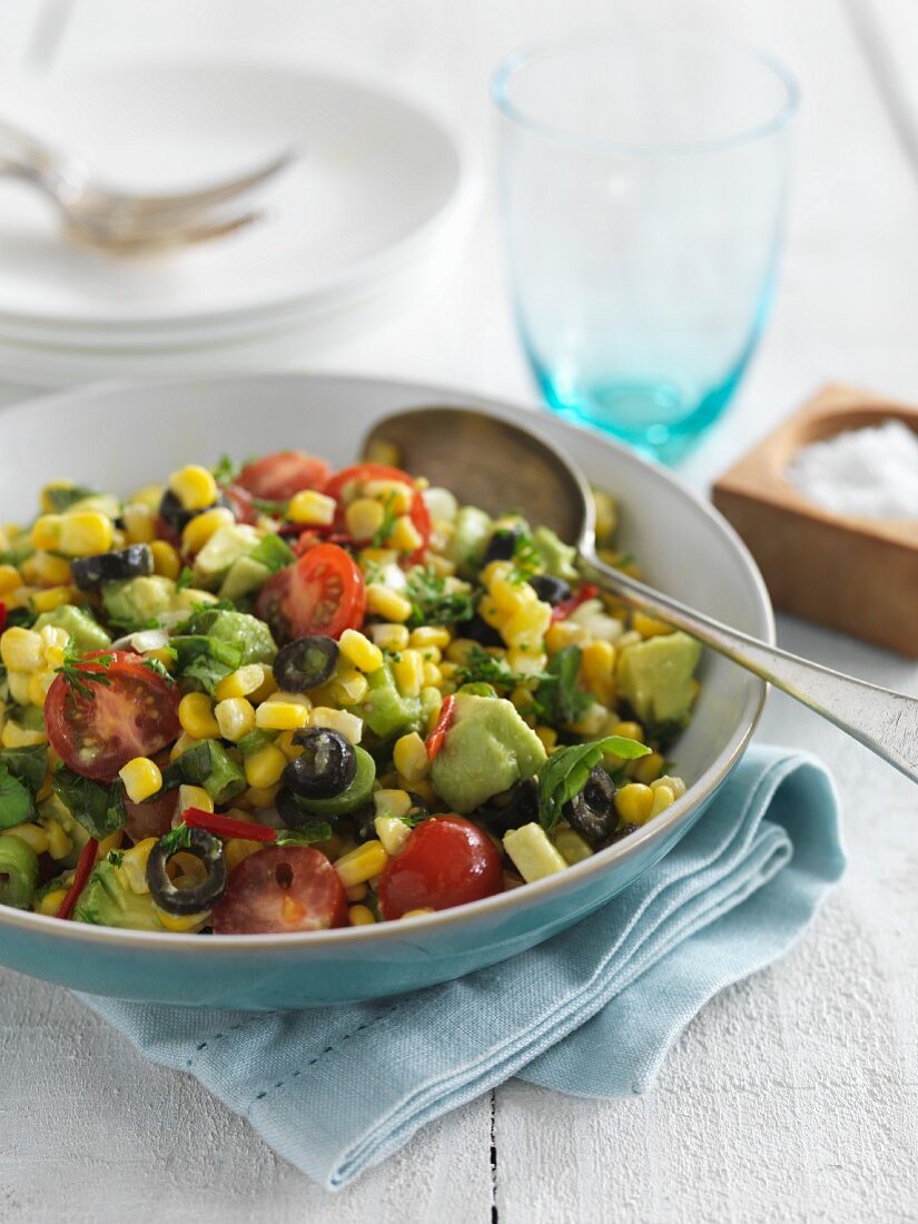 Corn salad with tomatoes, avocados, olives and basil