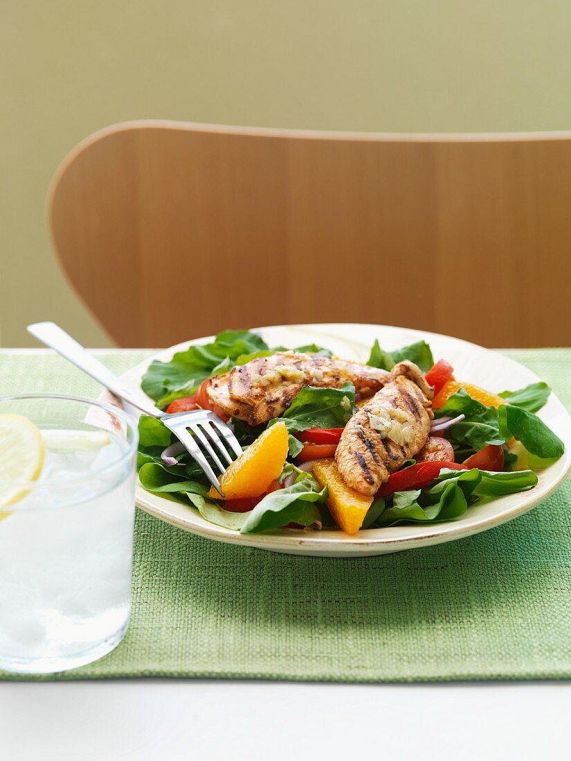 Salad with orange wedges with chicken breast strips