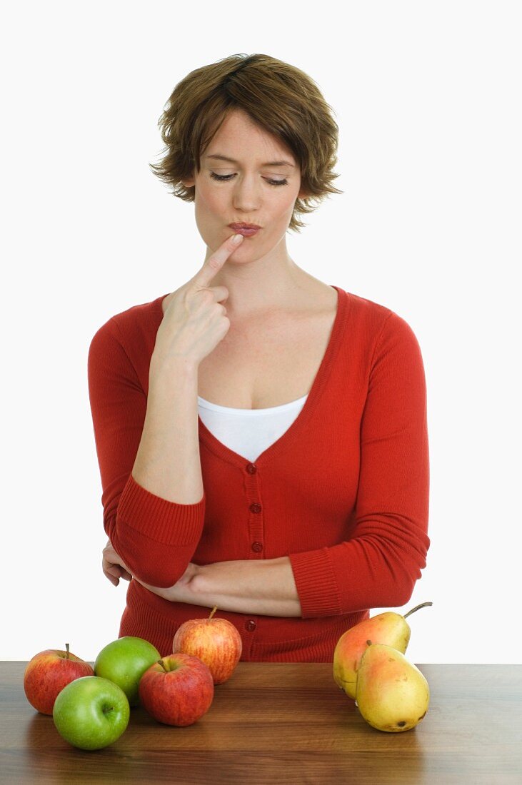 Thoughtful woman with apples and pears