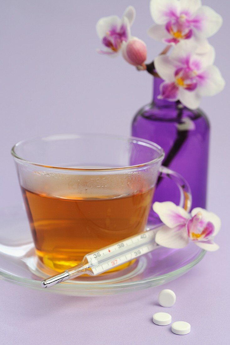 Tee, Fieberthermometer, Schüßler-Salze und Blume
