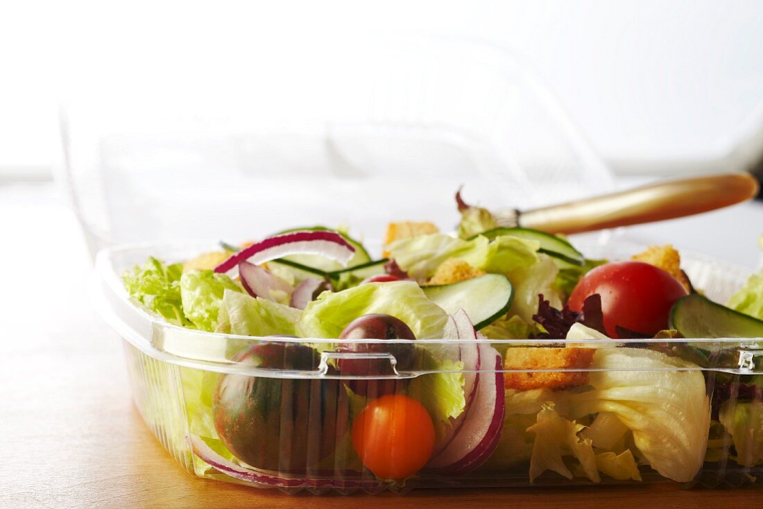 Gemischter Salat mit Croûtons im Plastikbehälter zum Mitnehmen