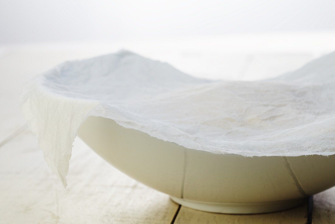 Homemade Dough Rising in a Bowl Covered with a Damp Paper Towel