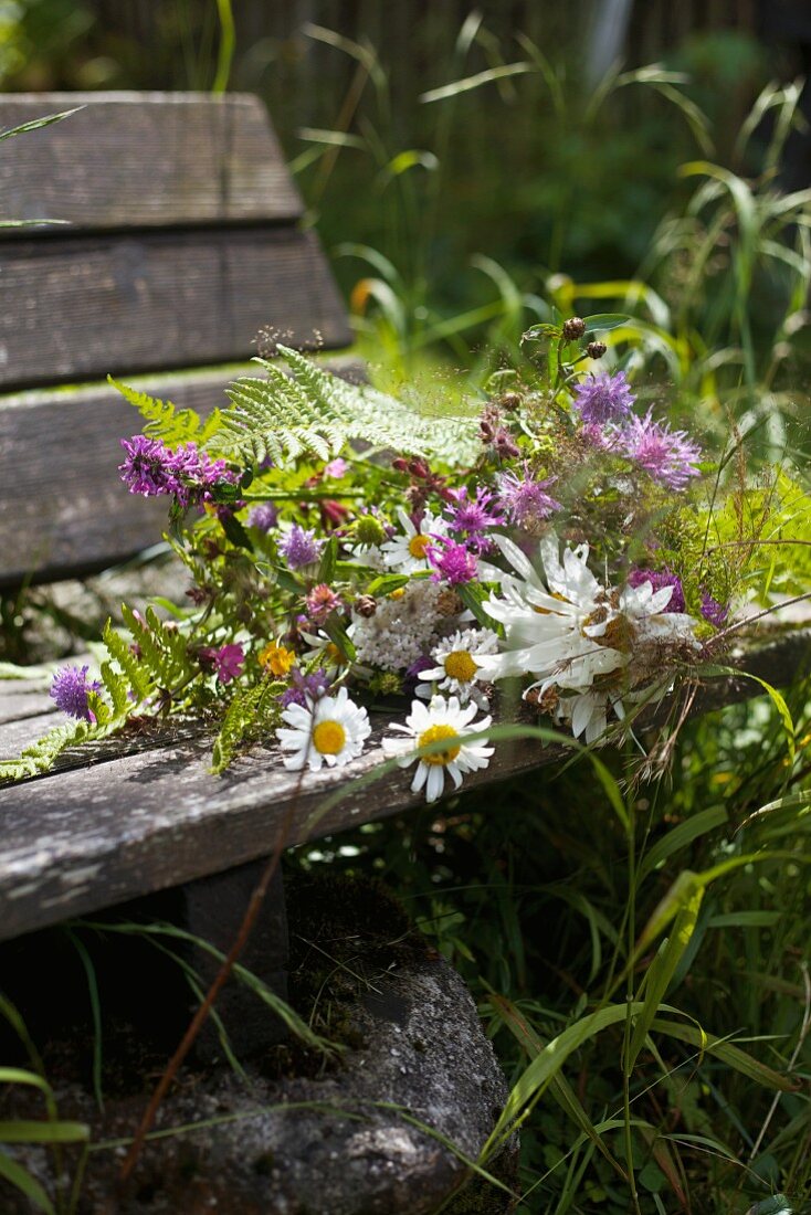 Bouquet of wild flowers on garden bench