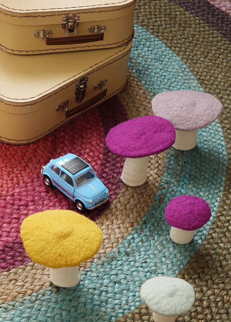 Decorative felt mushrooms and toy car on rug