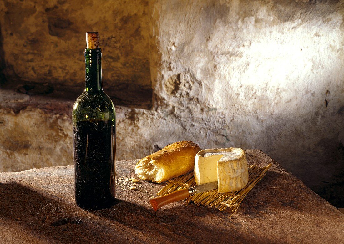 Still life with soft cheese, baguette & wine bottle