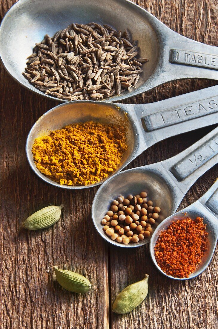 A Set of Measuring Spoons with Cumin, Turmeric, Mustard Seed, Chili Powder and Cardamom