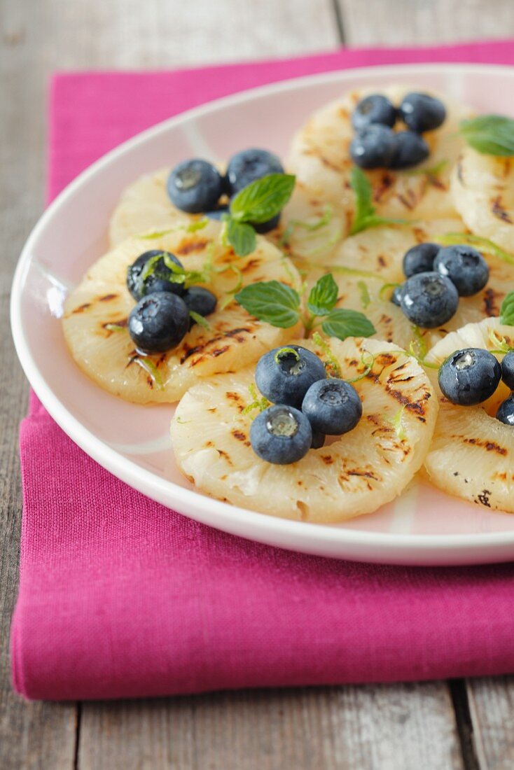 Grilled pineapple slices with honey and blueberries