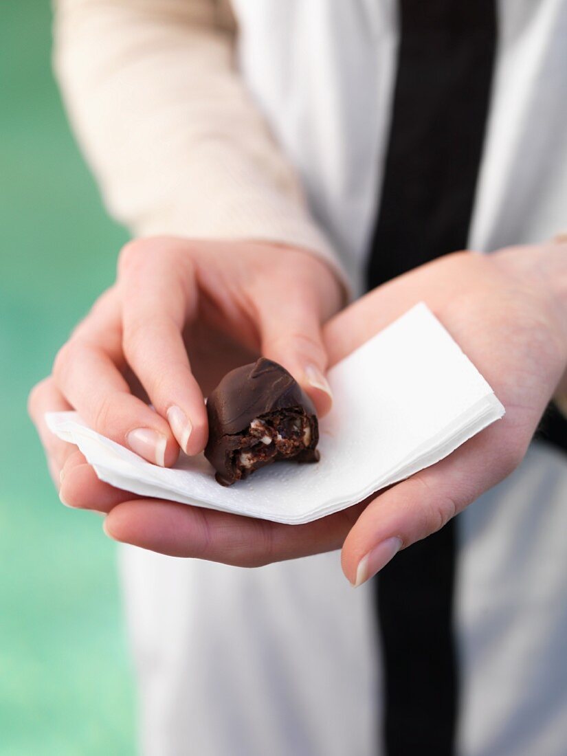 A woman holding a Rocky Road truffle praline