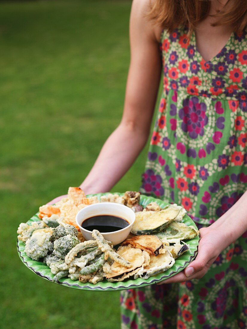 Mädchen hält Tempura mit Sojasauce