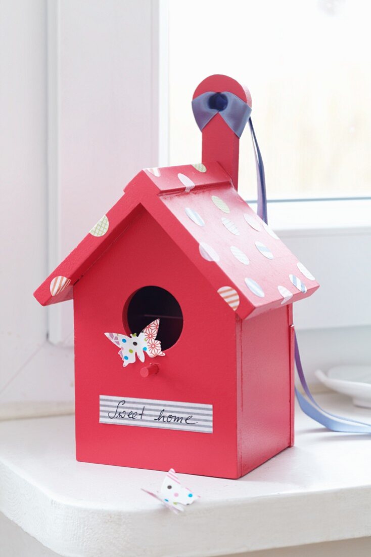 Romantic, pink bird box with label reading 'Sweet home' and tape spots