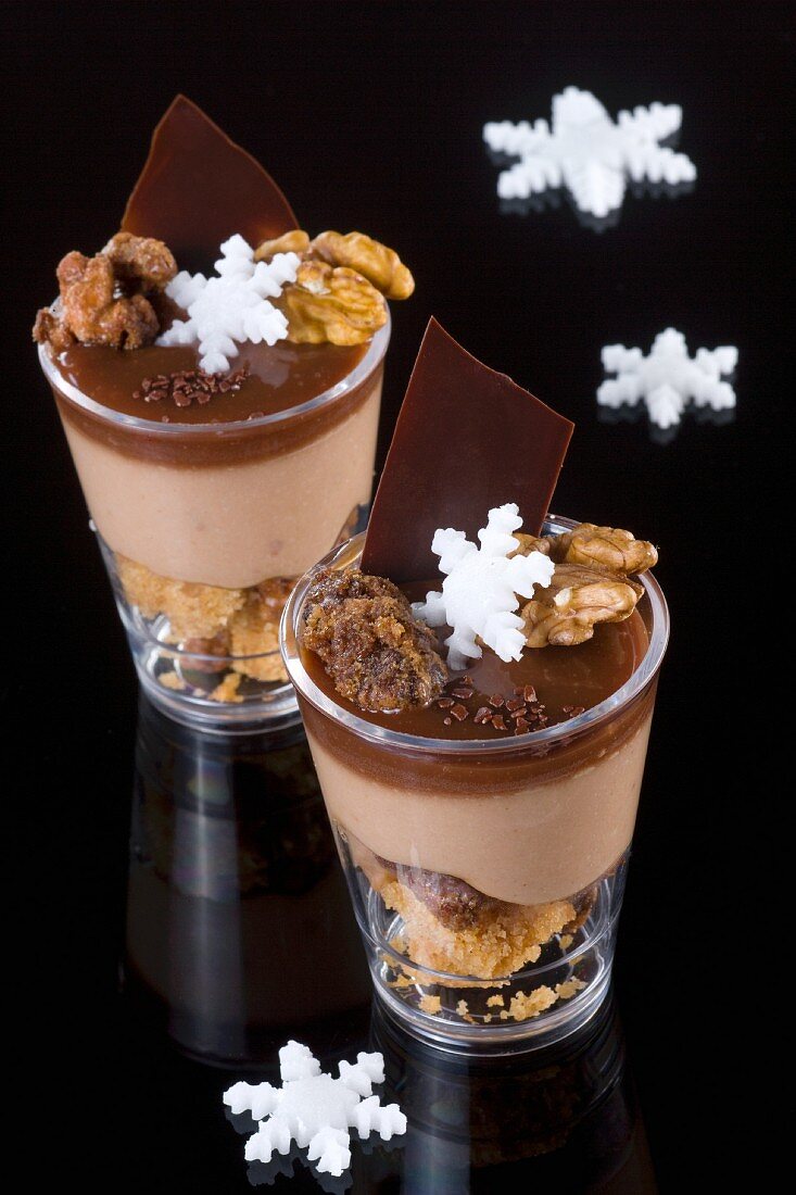 Two glasses of chocolate coffee mousse with nuts and sugar stars