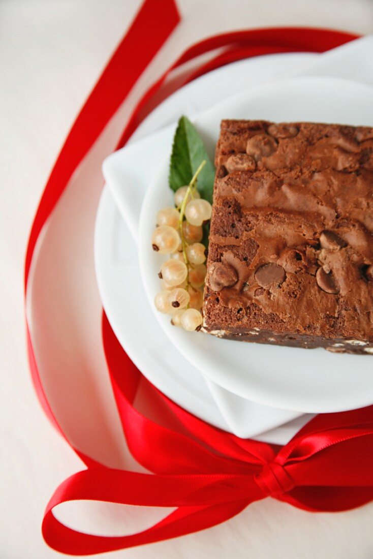 A Chocolate Chip Brownie with White Currants and a Red Ribbon