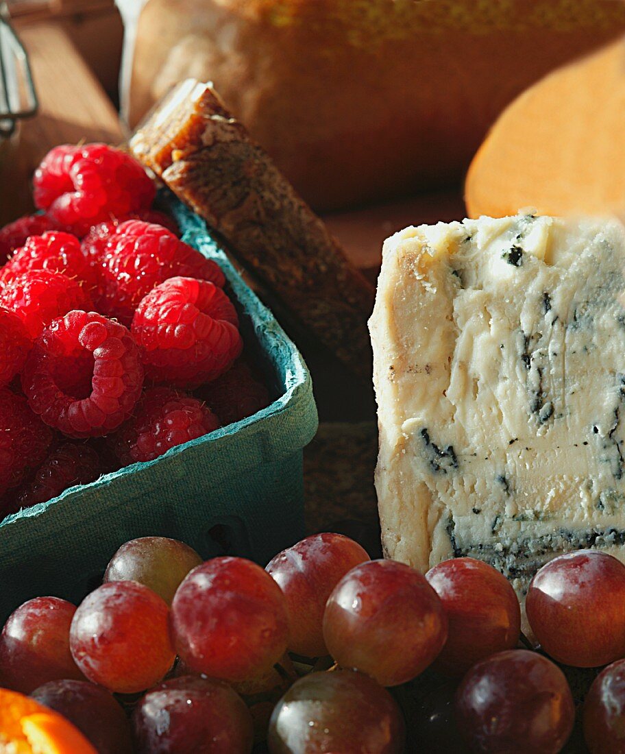 Wedge of Blue Cheese with a Pint of Raspberries and Fresh Grapes