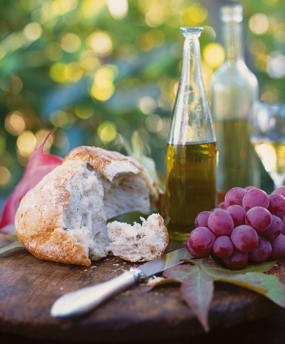 Rustikales Picknick mit Brot, Trauben und Wein