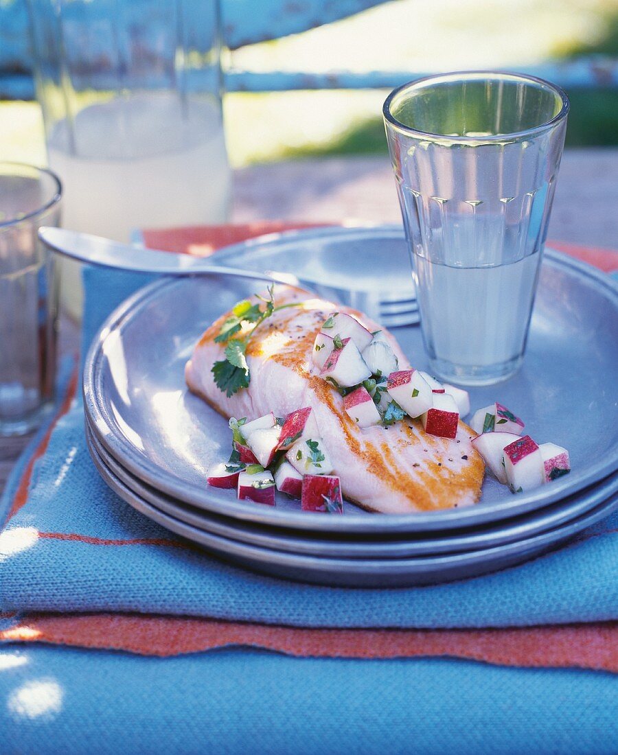 Salmon Filet with Nectarine and Serrano Chili Salsa; On a Plate on an Outdoor Table; With Lemonade