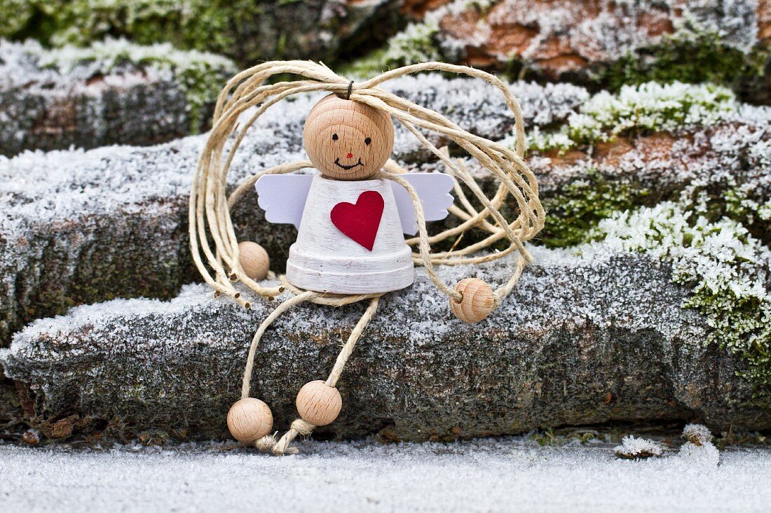 Christmas figurine sitting on stone outside