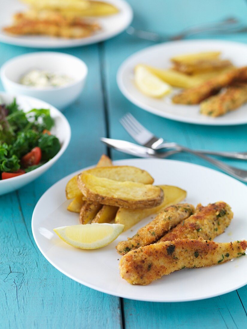 Fischfilets mit Parmesan-Zitronen-Panade und Kartoffelspalten