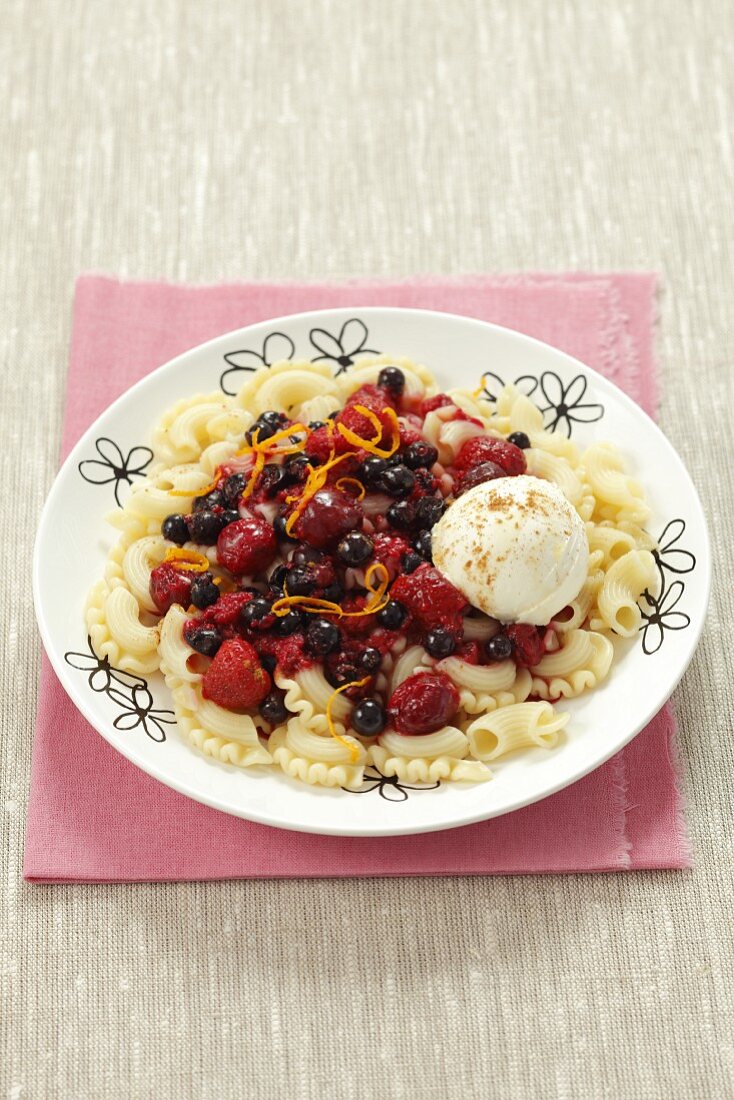 A sweet pasta dish with warm berries, vanilla ice cream and cinnamon