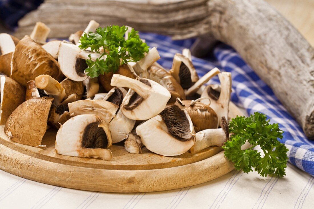 Geschnittene braune Champignons und Petersilie auf Schneidebrett