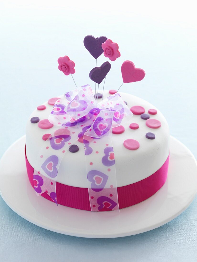 A celebratory cake decorated with hearts