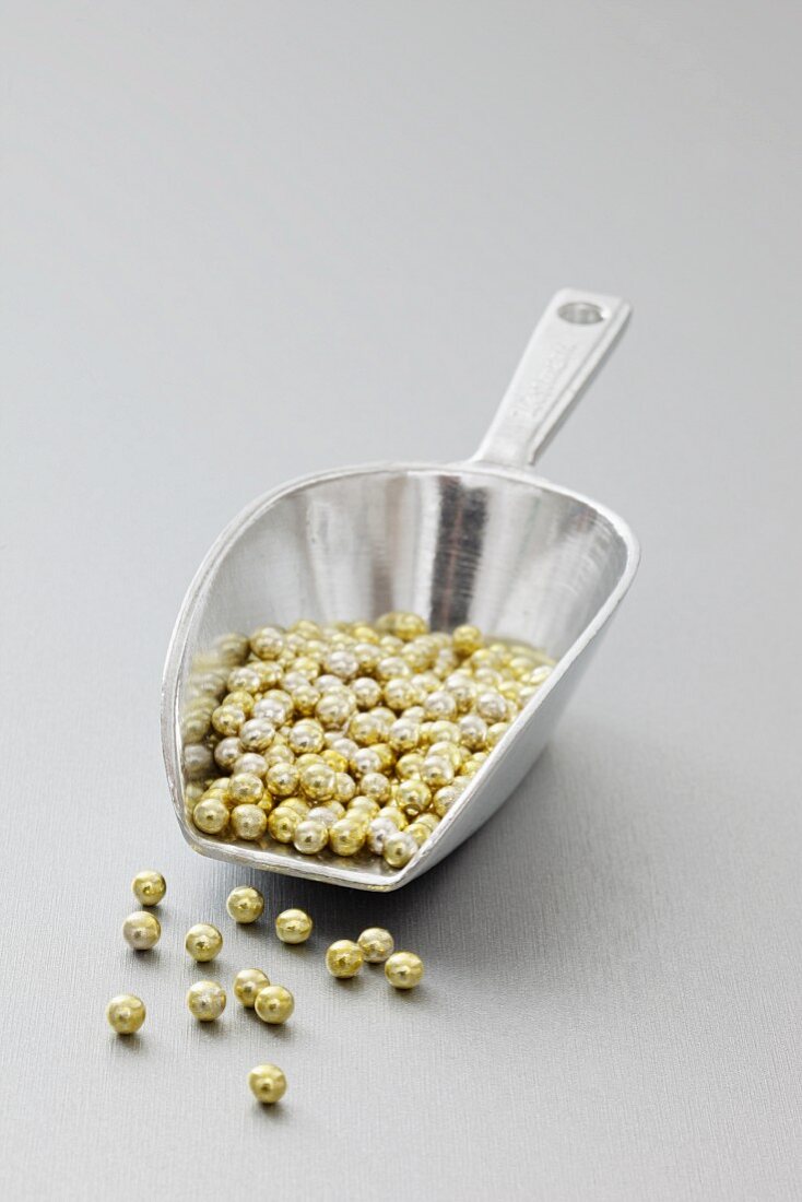 Gold beads in a metal scoop